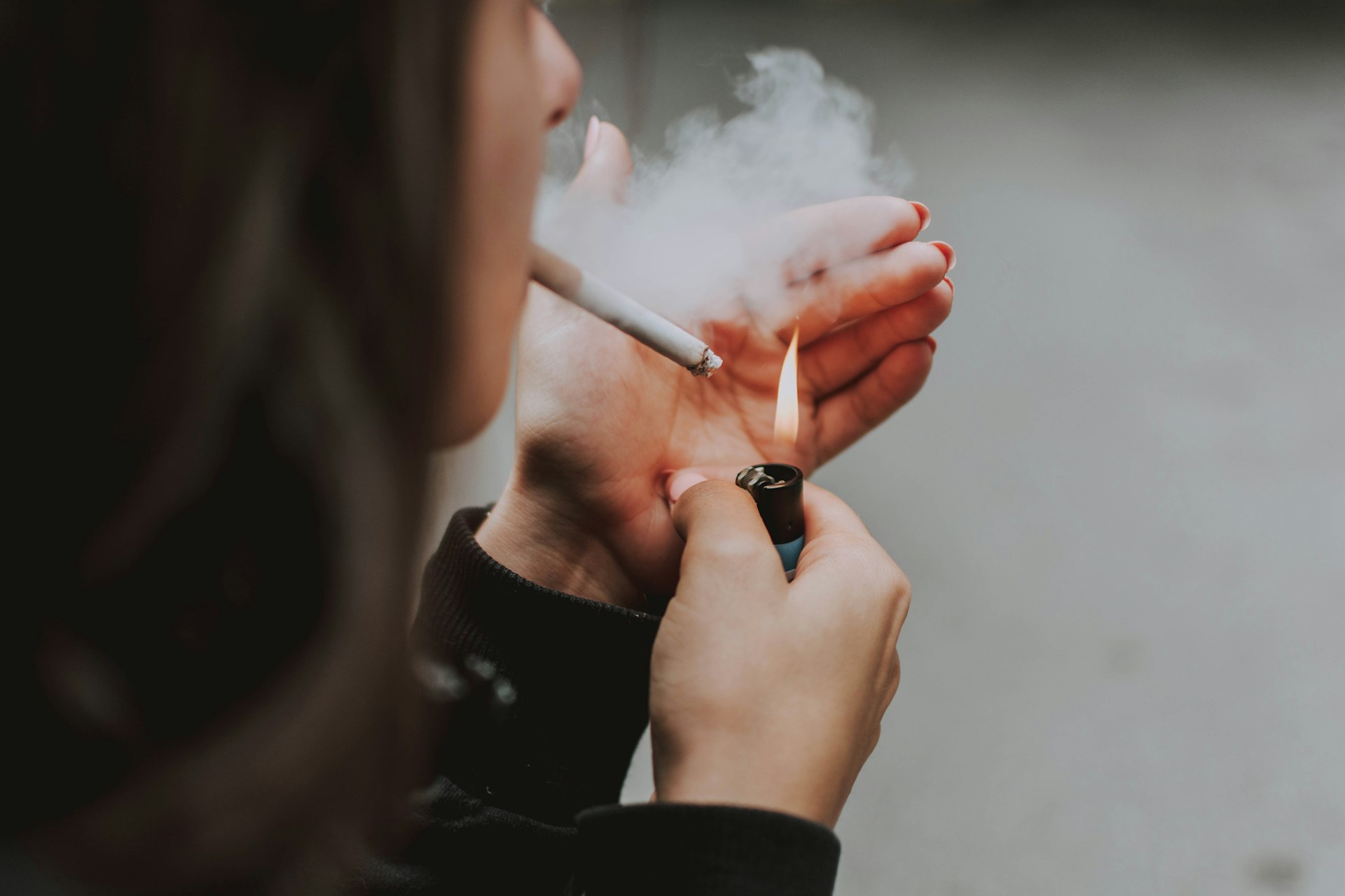 Smoking During Pregnancy and Preterm Birth Risk Close-up of a person lighting and smoking a cigarette.