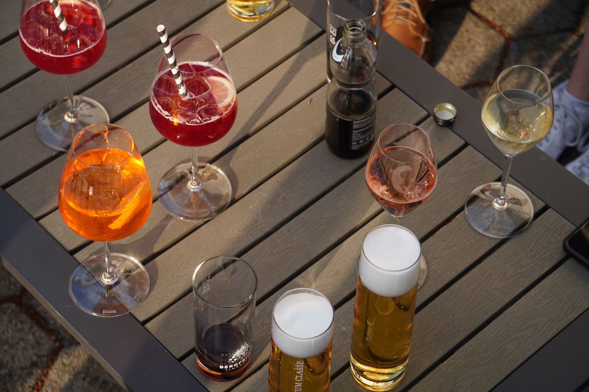 Alcohol Consumption and Preterm Birth Risk Assorted alcoholic drinks, including beer, wine, and cocktails, arranged on an outdoor table.
