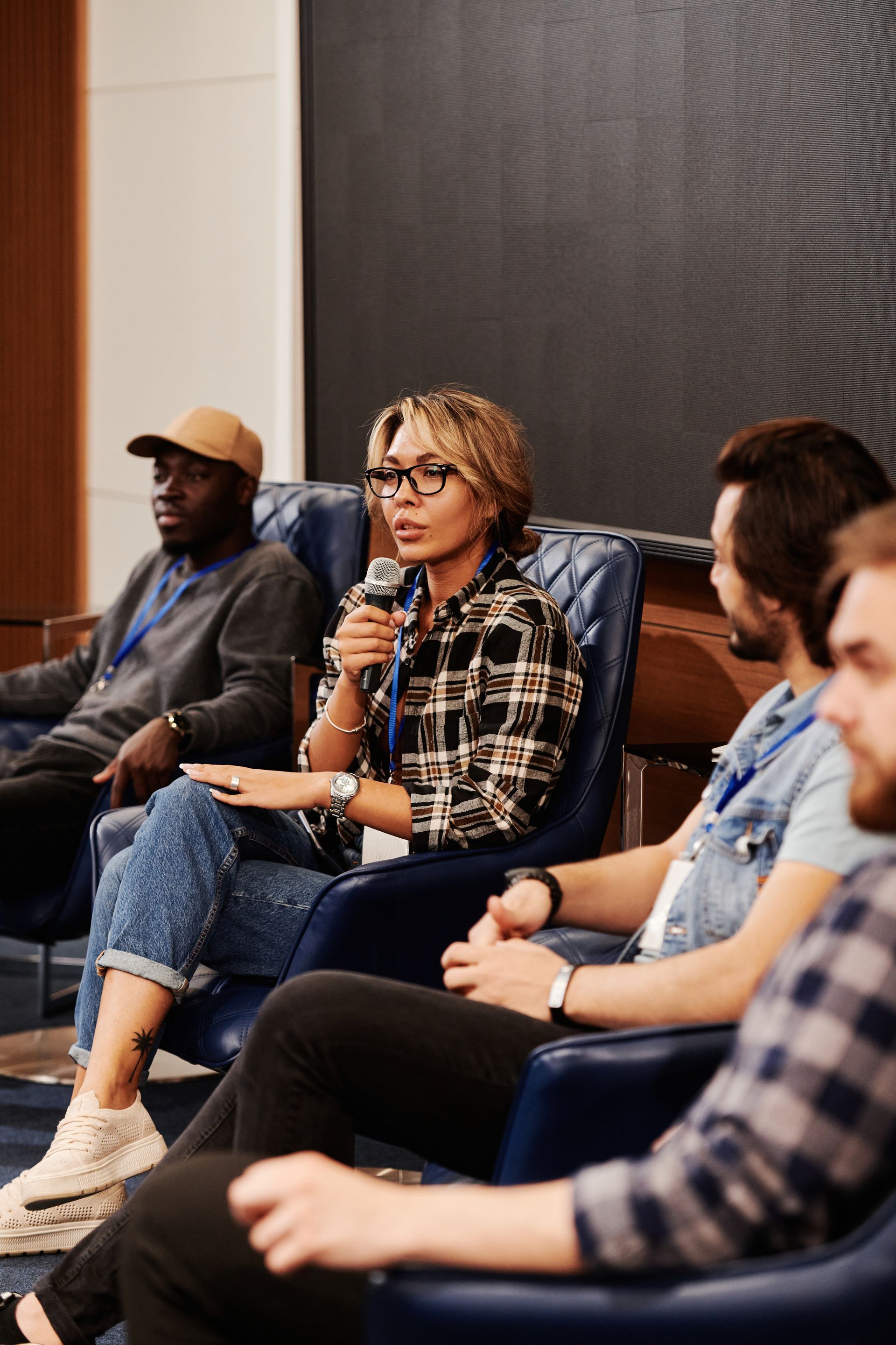 A participant speaking into a microphone during a professional panel discussion with other community partners.