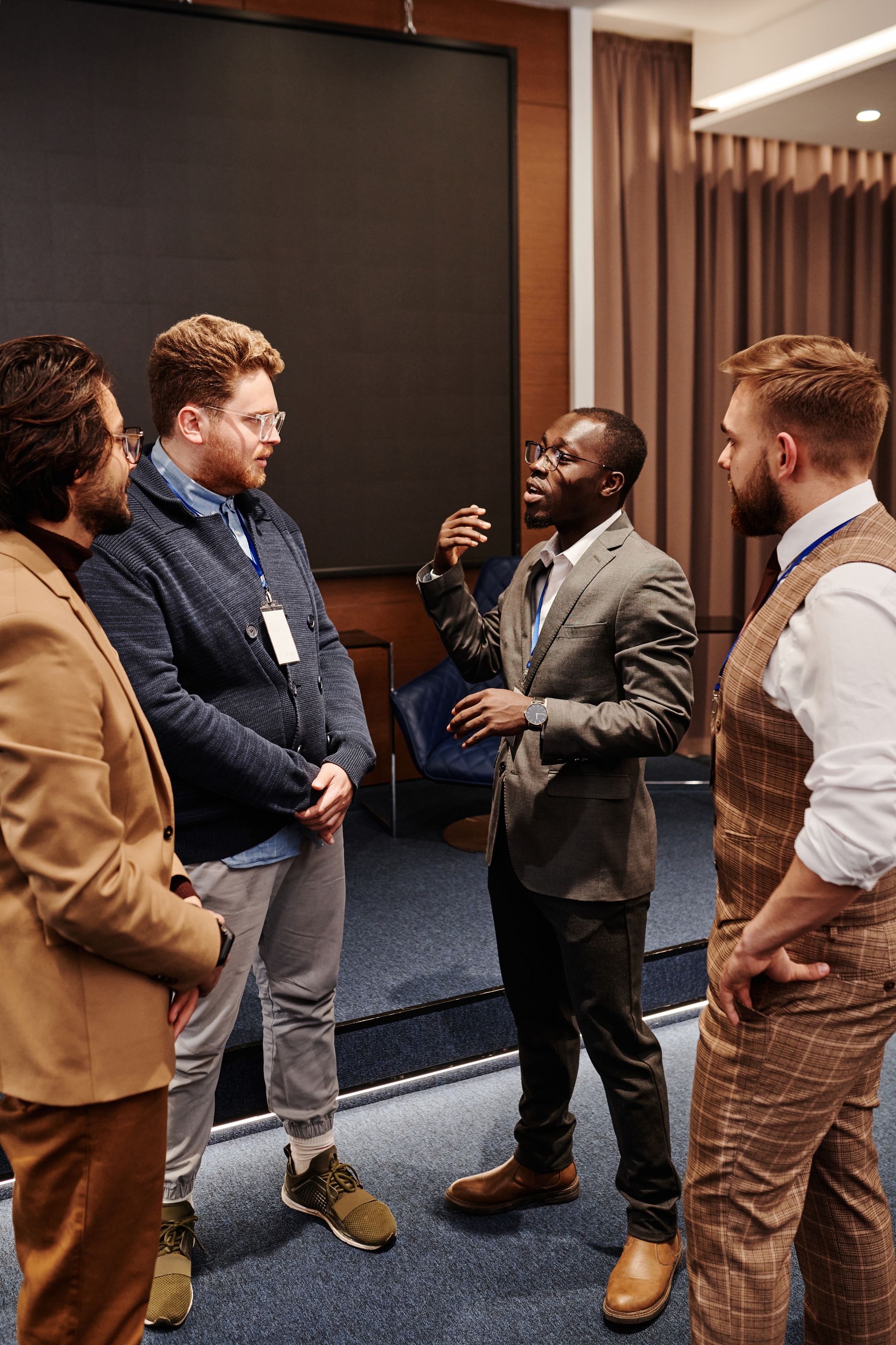 Professionals networking during a conference Four professionals standing together and talking during a conference networking session.