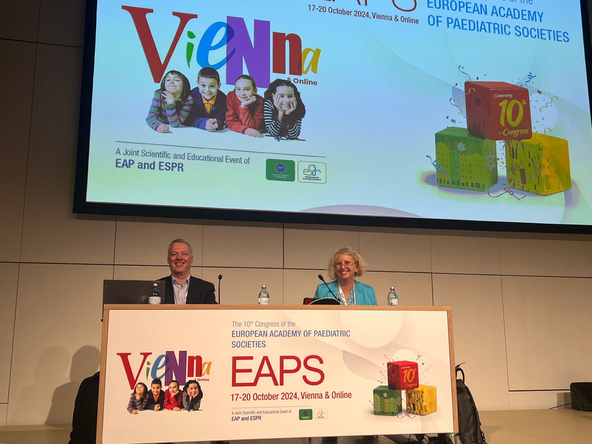 Panelists on stage at the EAPS 2024 Congress in front of a large screen with event branding and the theme celebrating the 10th Congress.