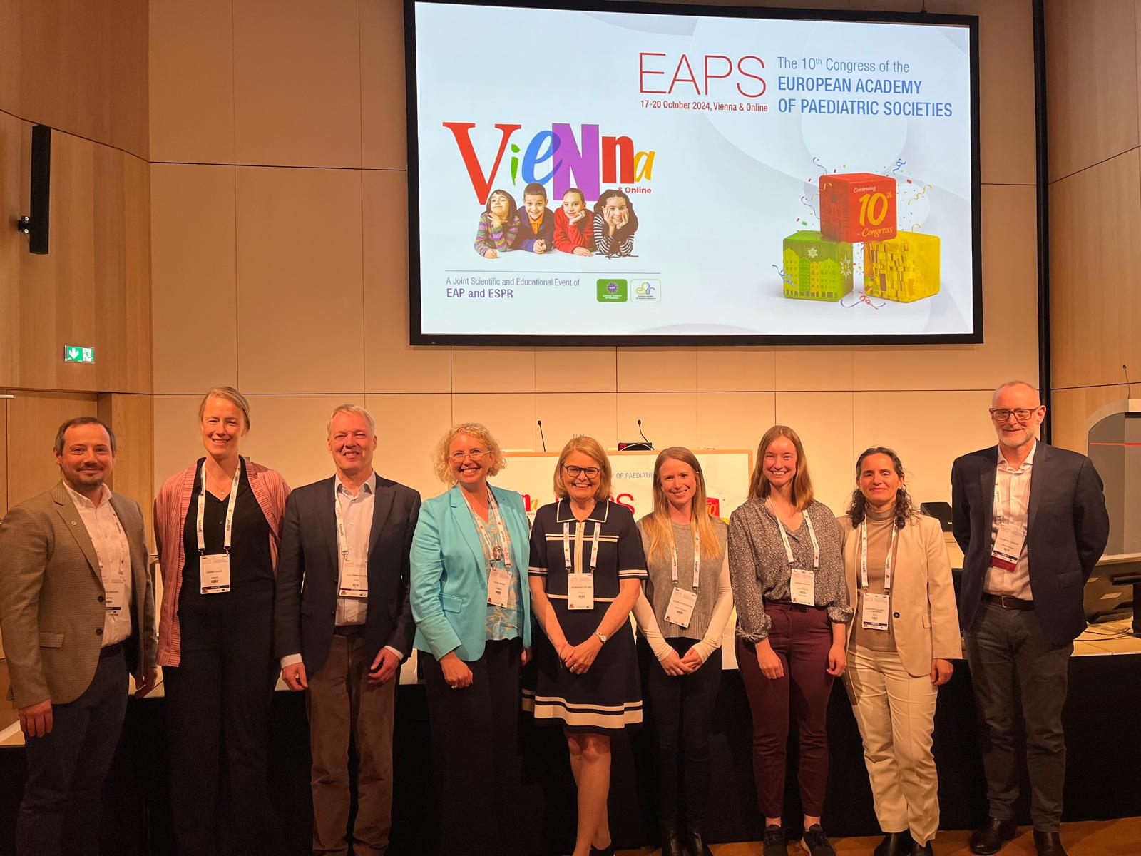 Group photo of speakers and participants at the EAPS 2024 Congress in front of a presentation screen showcasing the event’s branding.