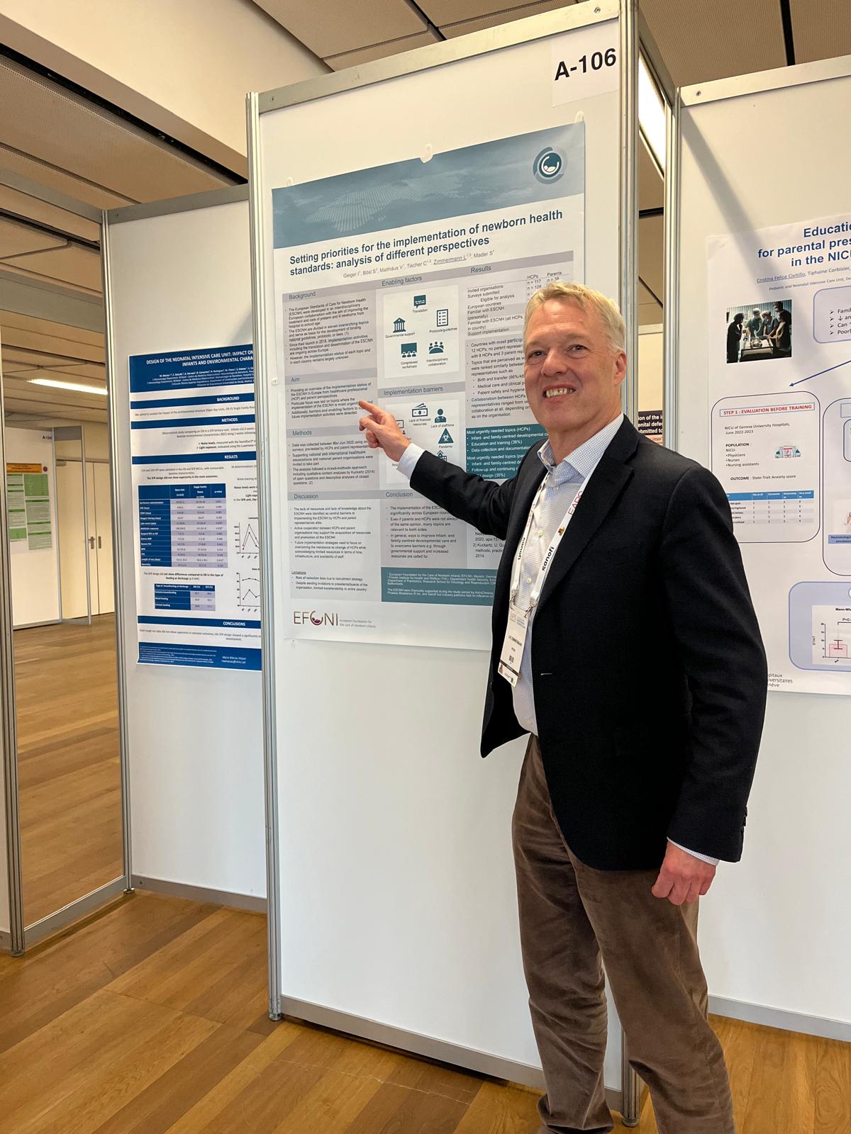 A presenter points to a poster titled “Setting priorities for the implementation of newborn health standards” during the poster session at EAPS 2024.