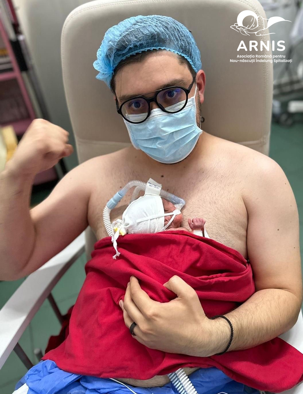 Father in medical gear holding his premature baby skin-to-skin during Kangaroo Mother Care in a Romanian NICU.