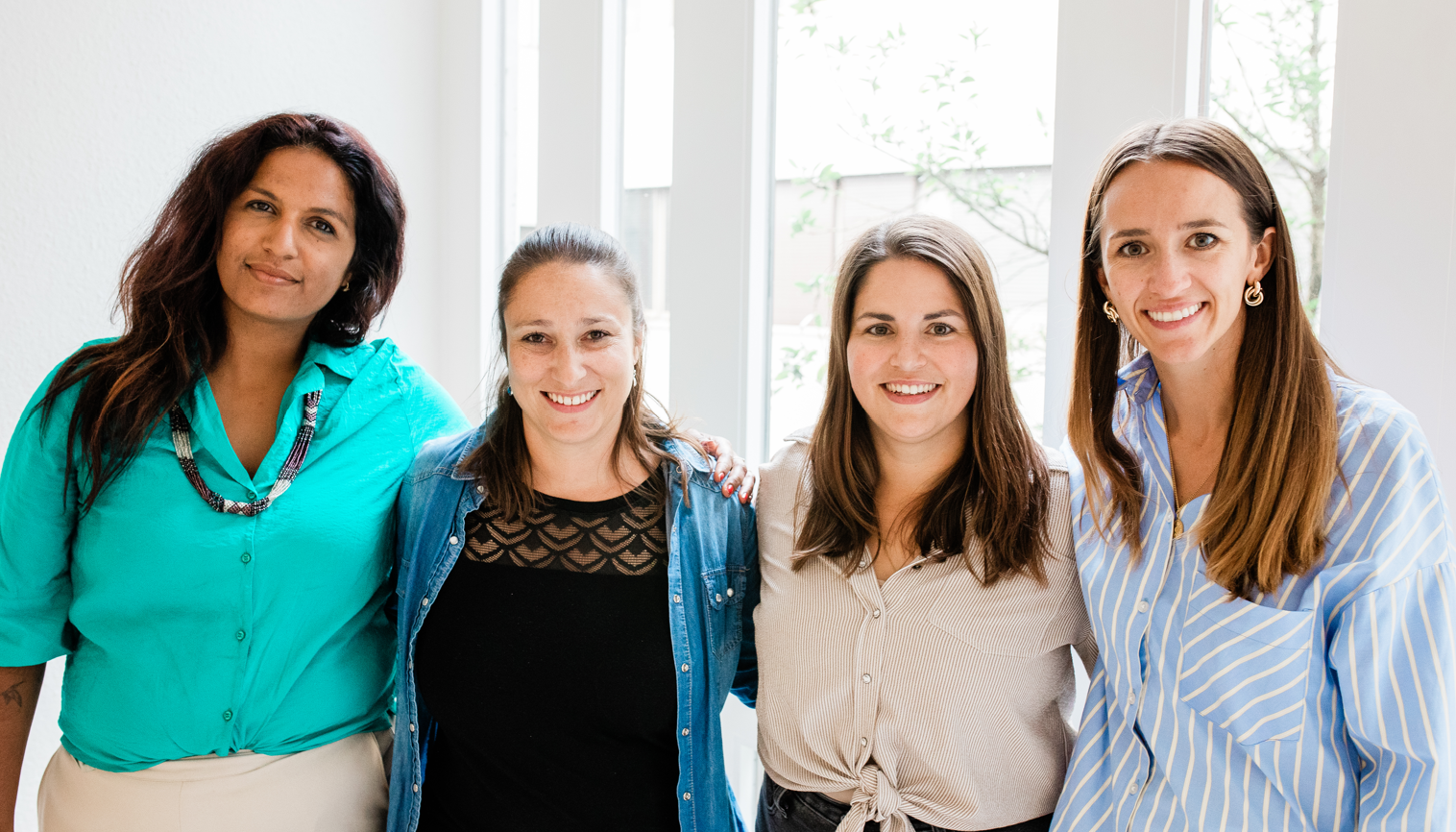 Four peer support teammembers stand together smiling, representing collaboration and community within Peer Support Switzerland.